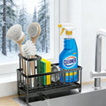Black metal sink caddy holding sponge, dish brush and cleaner beside a kitchen sink