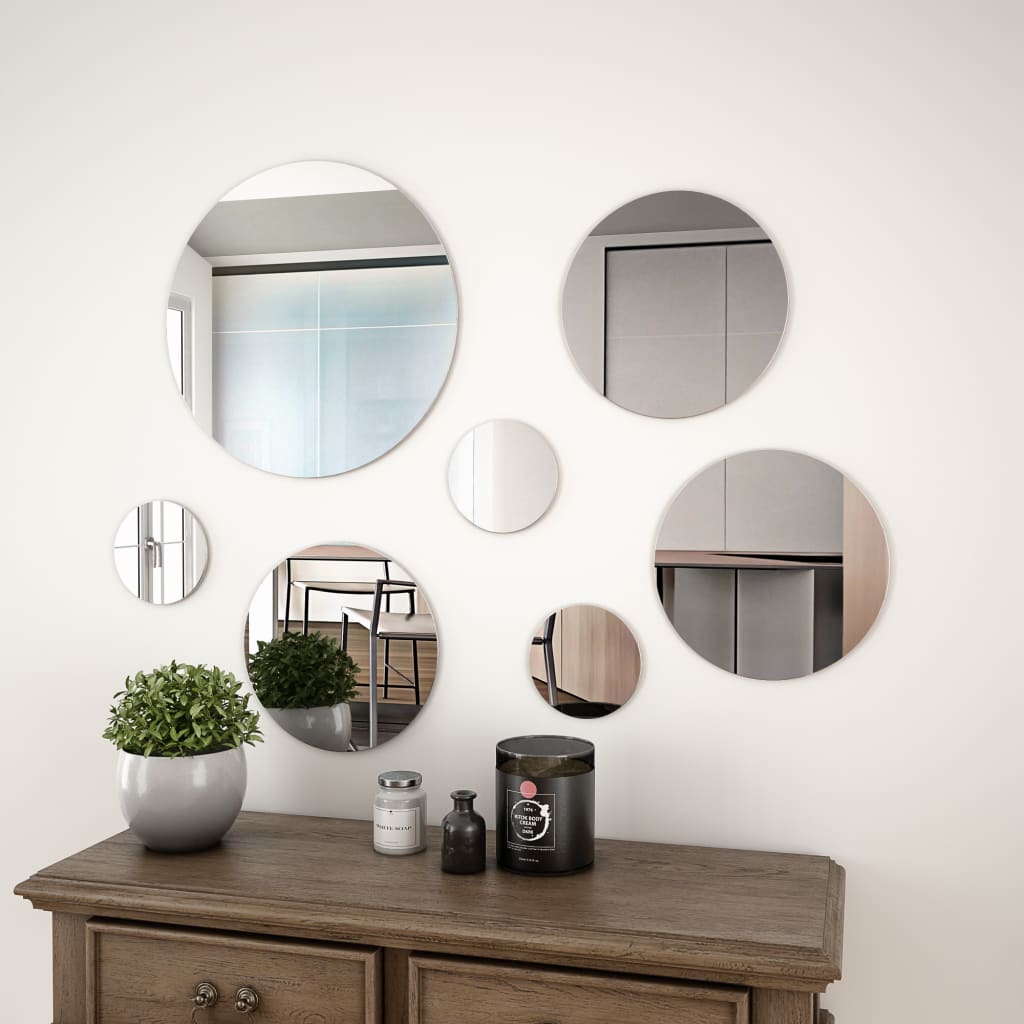 Round glass mirrors in three sizes arranged as wall decor